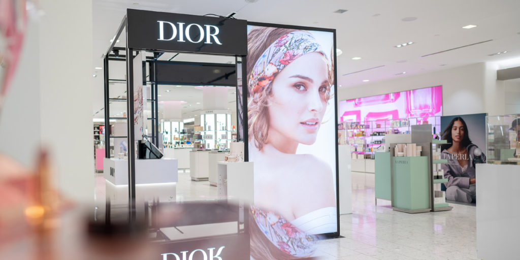 Modern lightbox storefront design with illuminated Dior logo and large backlit advertisement.
